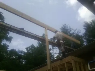 Carpenter setting a ridge beam over a new addition frame — Ice Dam Removal by Roofing Brothers in Ashippun