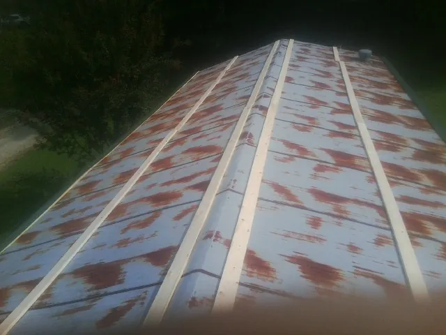Rusted metal roof panels with new wood purlins before replacement — Storm Damage Roof Repair in Ashippun by Roofing Brothers