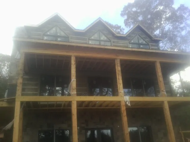 Dormers and porch framing on a large log home under construction — Roof Coating work by our crew in Ashippun