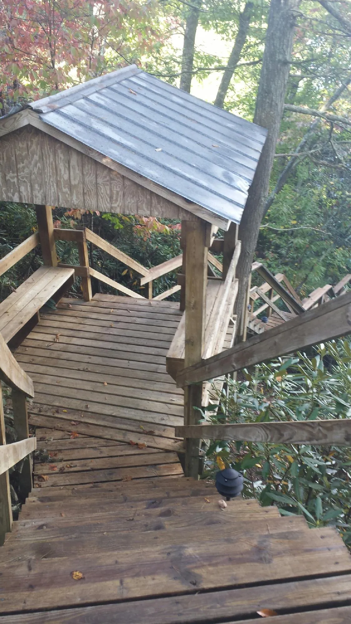 Metal roofed shelter over wooden steps on a wooded walkway — Skylight Repair & Installation work by our crew in Ashippun