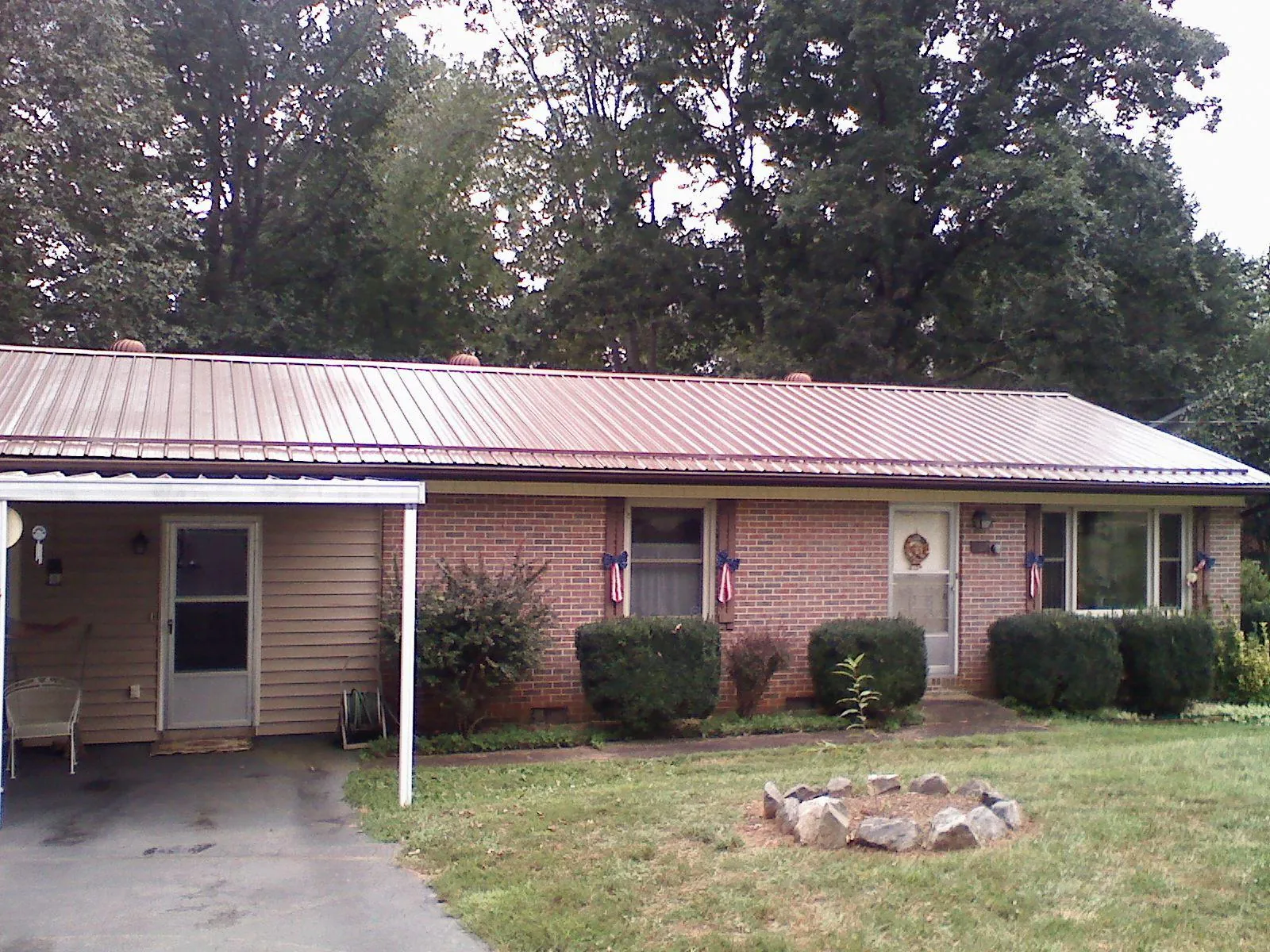 Bronze metal roof and carport on a brick ranch home — Roof Repair work by our crew in Ashippun