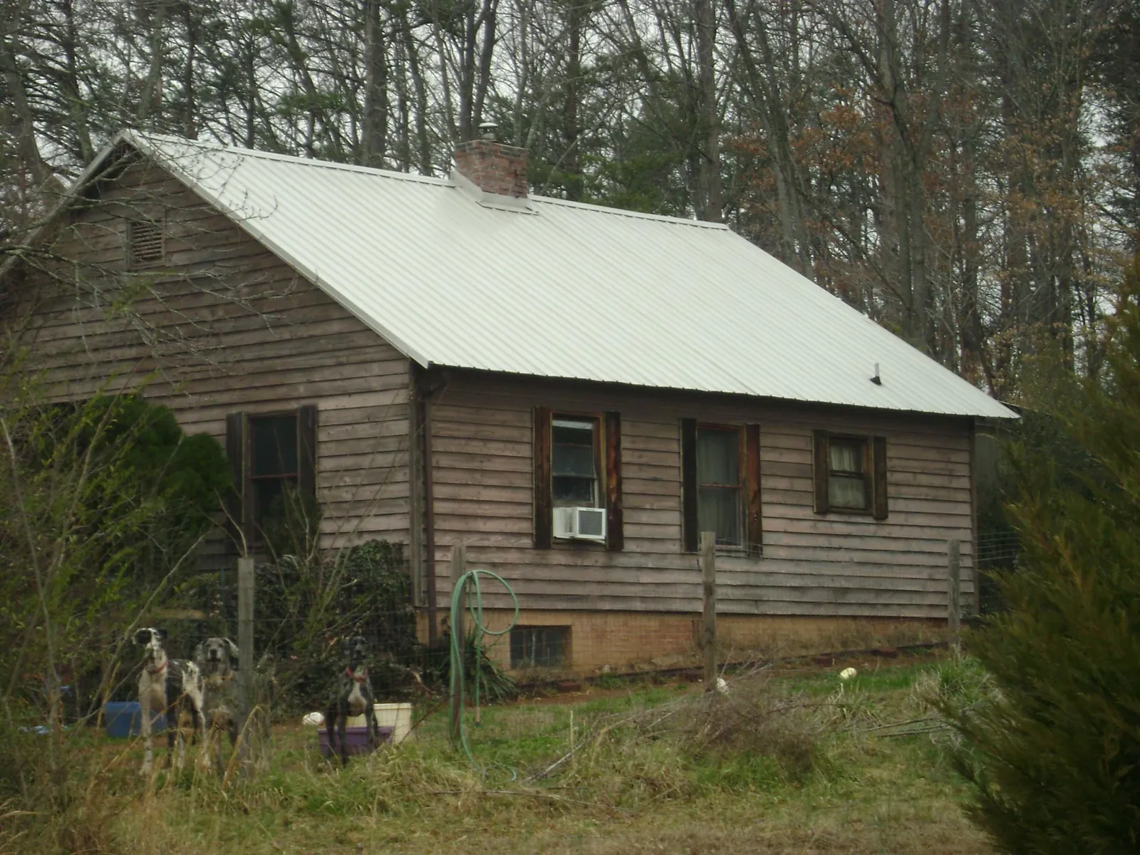 White metal roof on an old wood sided farmhouse, from a Metal Roof Installation job in Ashippun